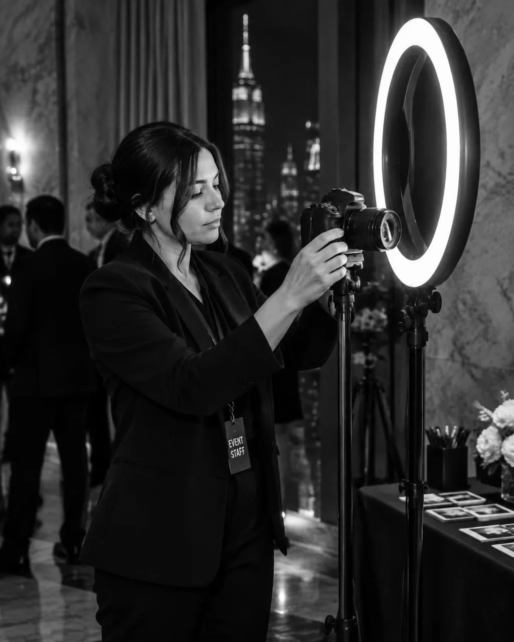 A booth attendant setting up the DSLR camera and ring light at a New York event